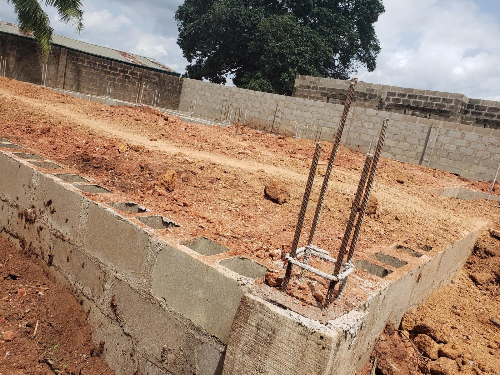 Pouring and compacting of laterite within the foundation — photo 1