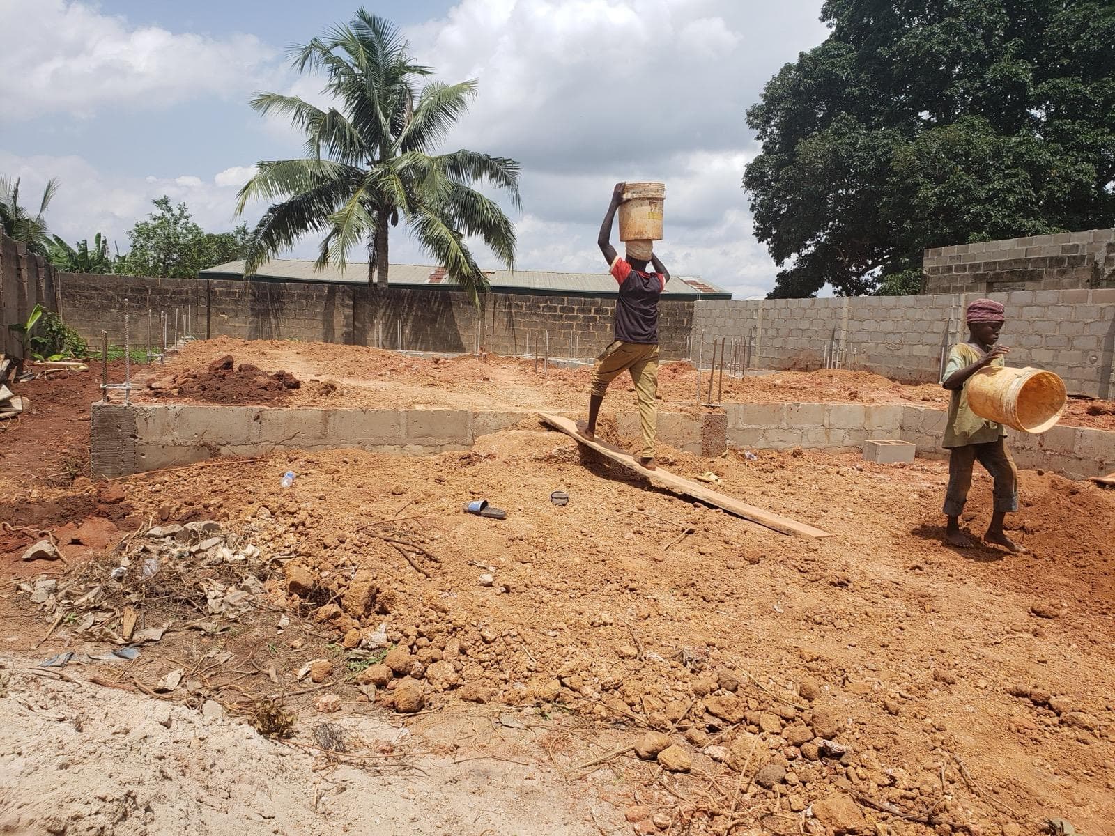 Pouring and compacting of laterite within the foundation — photo 3