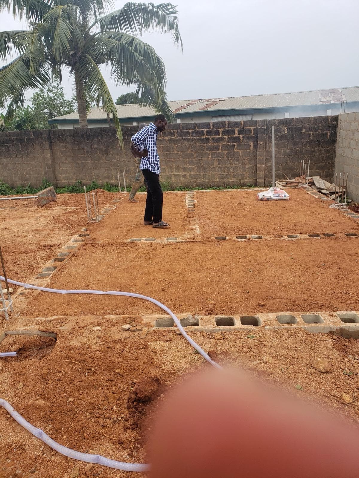 Pouring and compacting of laterite within the foundation — photo 5